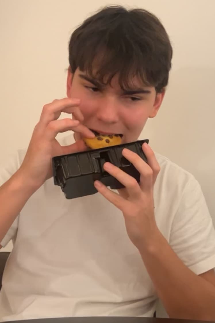 a chinese man eats a biscuit